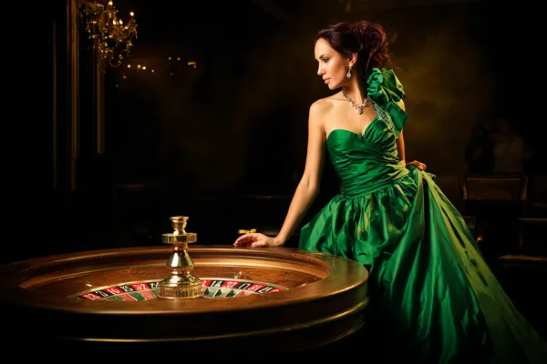 A stylish woman beside vibrant slot machines displaying glowing sevens, showcasing the variety of top slots at ZEUS75.