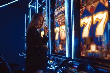 A woman smiling by bright slot machines showing lucky symbols, showcasing the exciting slot offerings at ZEUS75.